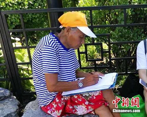 自称&ldquo;张老太&rdquo;的画师在什刹海附近画肖像。中新网记者 宋宇晟 摄